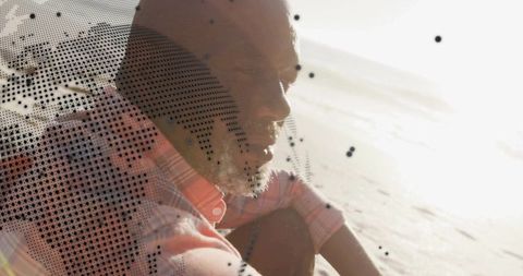 Contemplative man sitting on sunlit beach, facing glare, halftone texture and backlit silhouette