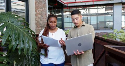 Multiracial team discussing work in modern office setting