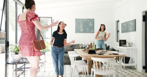 Excited Women Friends Preparing for Celebration in Bright Room