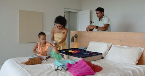 Family Packing Suitcase for Vacation in Bedroom