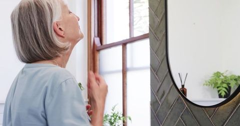 Woman enjoying tranquil morning routine in home bathroom