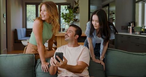 Diverse Friends Sharing Moment on Smartphone in Modern Living Room