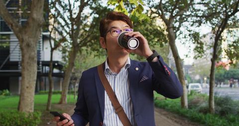 Business Professional Walking in Park with Coffee and Smartphone