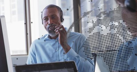 Businessman using headset for global communication in modern office