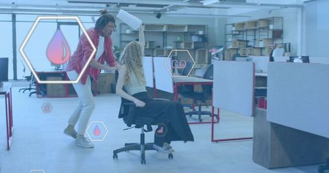 Colleague pushing coworker on rolling chair in open-plan office with hex ui overlays