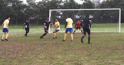 Intense soccer match with players contesting ball near goal
