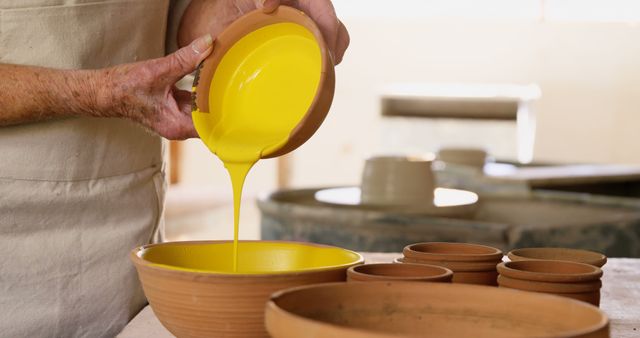 Artisan Pouring Bright Yellow Glaze into Ceramic Bowl - Download Free Stock Images Pikwizard.com