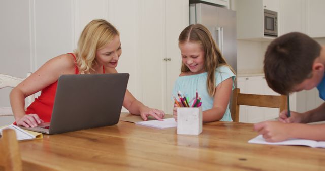 Caucasian mother helping her daughter with homework while using laptop at home. family, love and togetherness concept
