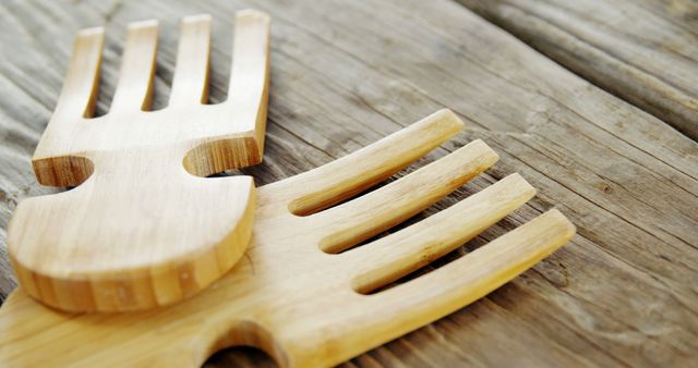 A wooden salad fork and spoon rest on a rustic table, with copy space. These utensils add a natural touch to the presentation of a meal and are eco-friendly alternatives to plastic.