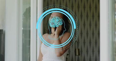 Asian woman holding smartphone by sunlit window with blue brain tech overlay for telehealth