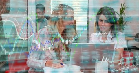 Female colleagues collaborating on laptop with stock market charts overlay for finance teams