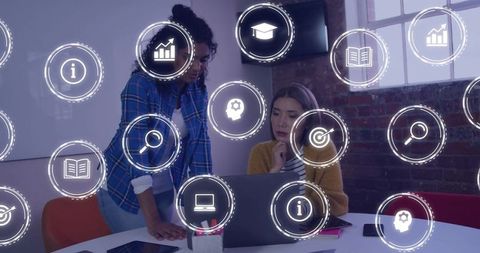 Two Women Collaborating on Laptop with Holographic Analytics Icons and Teamwork Concept