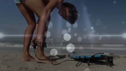 Man Securing Surfboard Leash on Sandy Beach With Vibrant Animated Elements
