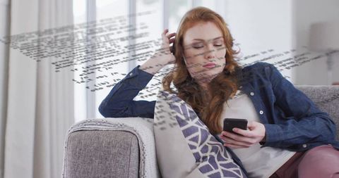 Woman Relaxing on Sofa With Code Overlays and Smartphone