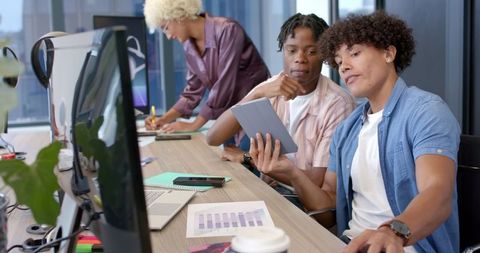 Diverse team collaborating on business project with tablet