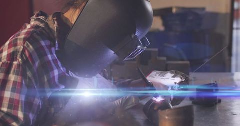 Mechanic engaged in precision welding in automotive workshop