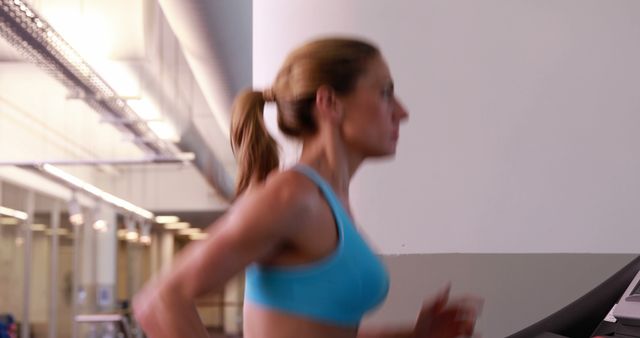 Focused woman running on treadmill in modern gym - Download Free Stock Images Pikwizard.com