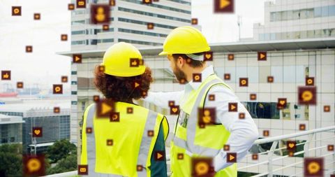 Construction inspectors pointing at city skyline on rooftop with social media icons