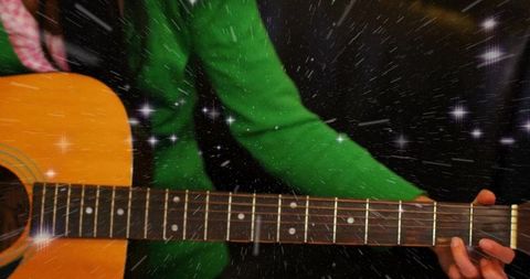 Woman in Green Sweater Strumming Acoustic Guitar with Starburst Effect