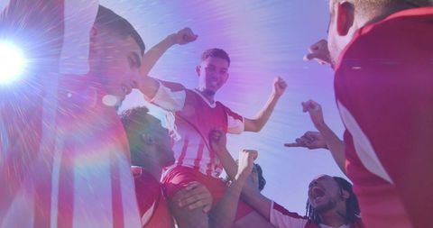 Soccer Team Lifting Triumphant Player in Victory Celebration