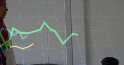 Hijab-wearing businesswoman presenting modern office graph presentation