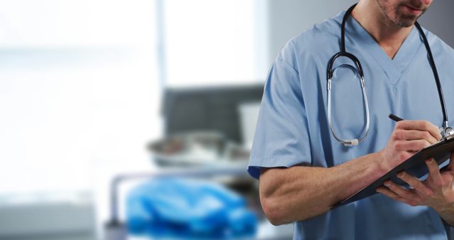 Medical Professional in Scrubs Taking Notes with Stethoscope in Hospital - Download Free Stock Images Pikwizard.com