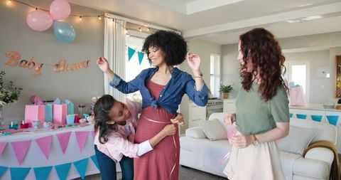 Women celebrating joyful baby shower with games and decorations