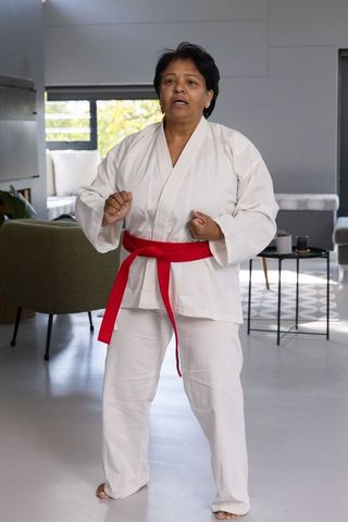 Senior Indian Woman Practicing Martial Arts in Modern Living Room