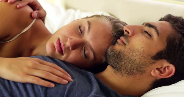 Cute couple sleeping and cuddling in bed at home in bedroom