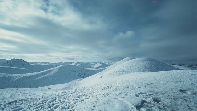 Serene snow-covered hills under overcast sky