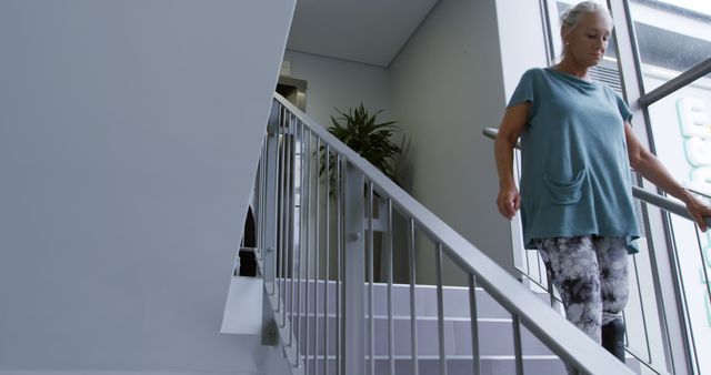 Active Senior Woman Walking Down Stairs Indoors - Download Free Stock Images Pikwizard.com