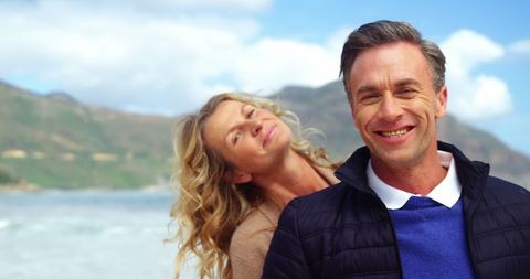 Happy Middle-Aged Couple Enjoying Beach Breeze