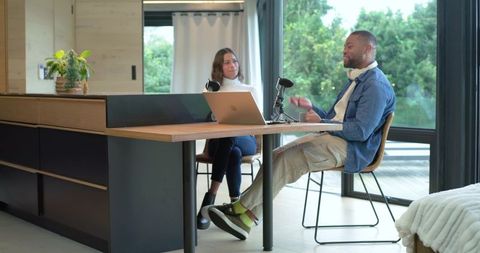 Recording podcast in bright home studio with diverse coworkers and casual conversation