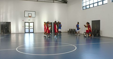 Diverse Basketball Team Celebrating Victory on Indoor Court