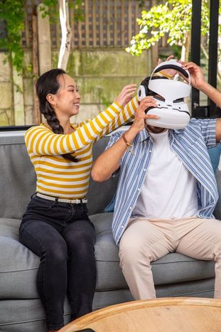 Couple enjoying vr technology together on patio sofa