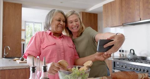 Mother and Daughter Taking Selfie in Modern Kitchen