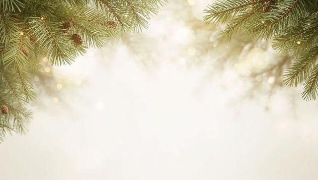 Evergreen pine branch border with warm bokeh lights and pine cones for holiday design