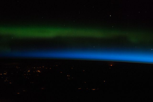 Aurora Borealis captured from International Space Station. Green and blue hues dominate the night sky above northeastern Kazakhstan. Suitable for articles on space exploration, science education, natural phenomena, and night sky wallpapers.