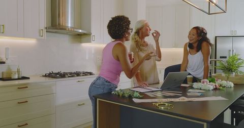 Women collaborating on wedding plans in modern kitchen