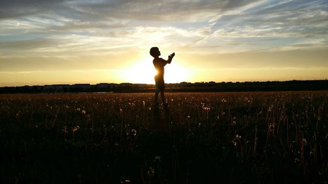 Silhouette of Child Playing in Field at Sunset - Download Free Stock Photos Pikwizard.com