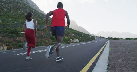 Fit Couple Jogging on Mountain Road During Morning Workout