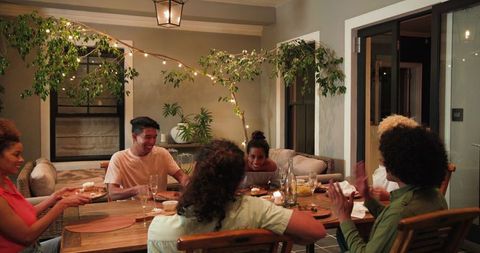 Diverse group celebrating together at dinner party