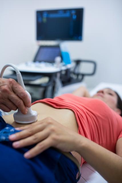Woman getting ultrasound of a abdomen from doctor in hospital