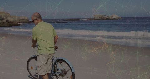 Senior man walking bicycle along sunlit rocky shoreline for active retirement lifestyle