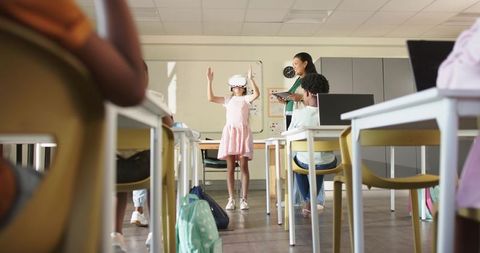 Student exploring vr headset in classroom while classmates and asian teacher using tablet