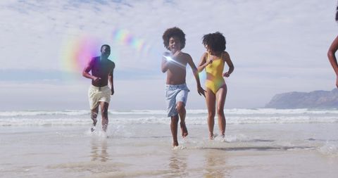 Joyful African American Family Playing at Beach with Light Effects