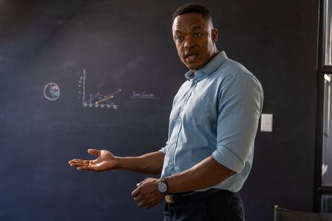 Professional Educator Presenting Data on Chalkboard