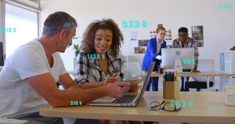 Diverse team collaborating over laptop and smartphone in bright modern office with data overlays