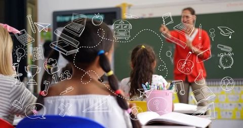 Teacher Pointing at Chalkboard While Students Listening in Colorful Elementary Classroom