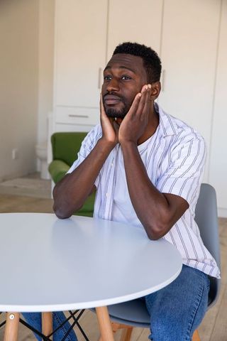Thoughtful man sitting calmly at home table